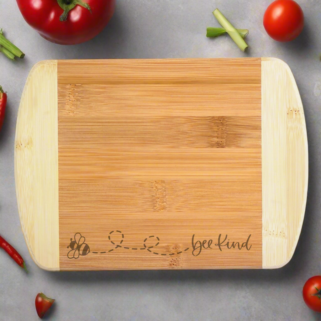 Bamboo cutting board with 'bee kind' engraving on a white background