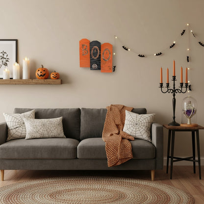 Living room decorated for Halloween with pumpkins, candles, and spider webs.