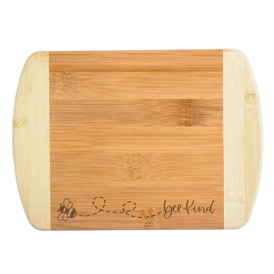 Bamboo cutting board with 'bee kind' engraving on a white background