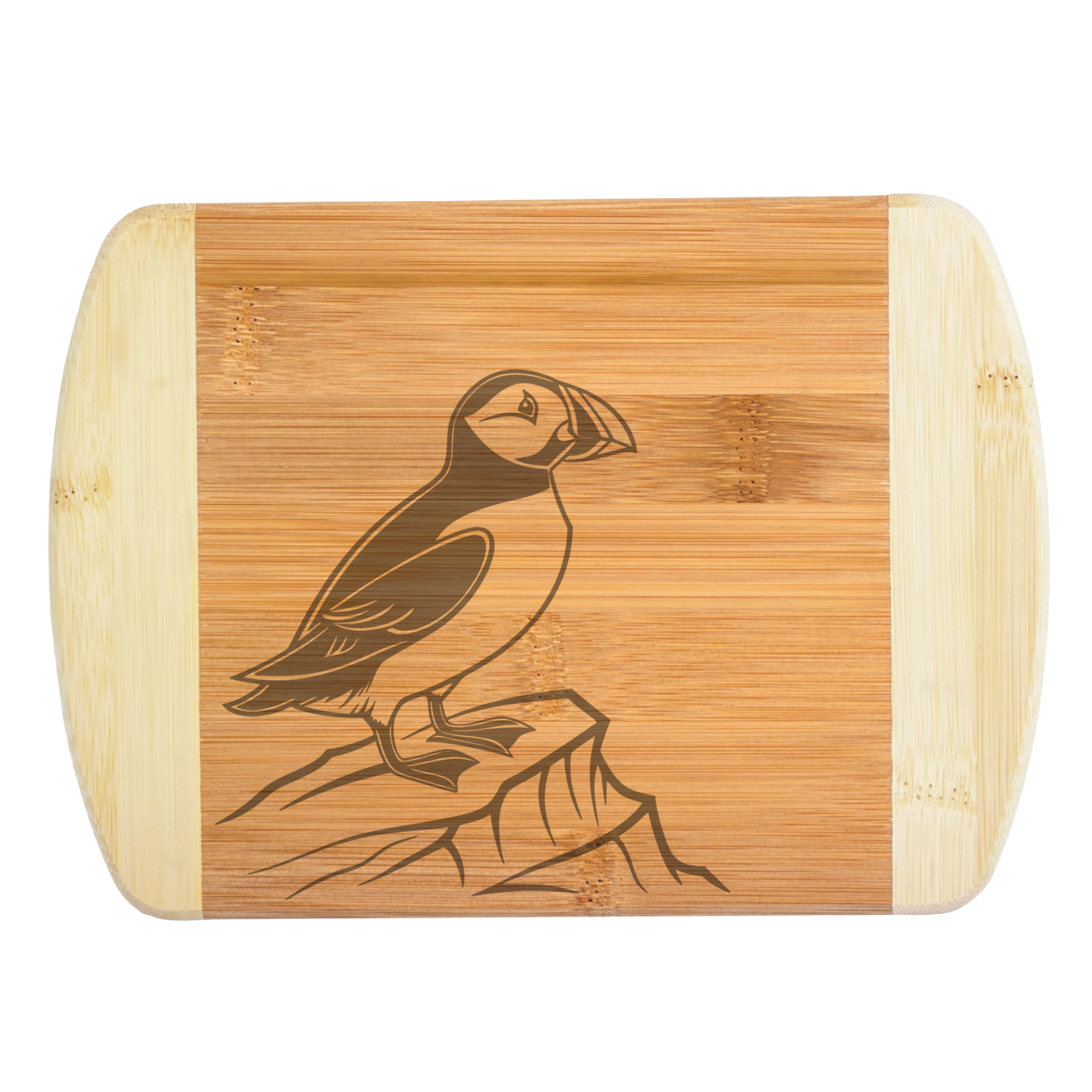 A premium engraved bamboo cutting board showcasing a detailed illustration of a puffin bird standing on a rocky coastal cliff, handcrafted by The Blended Oasis in Washington State.