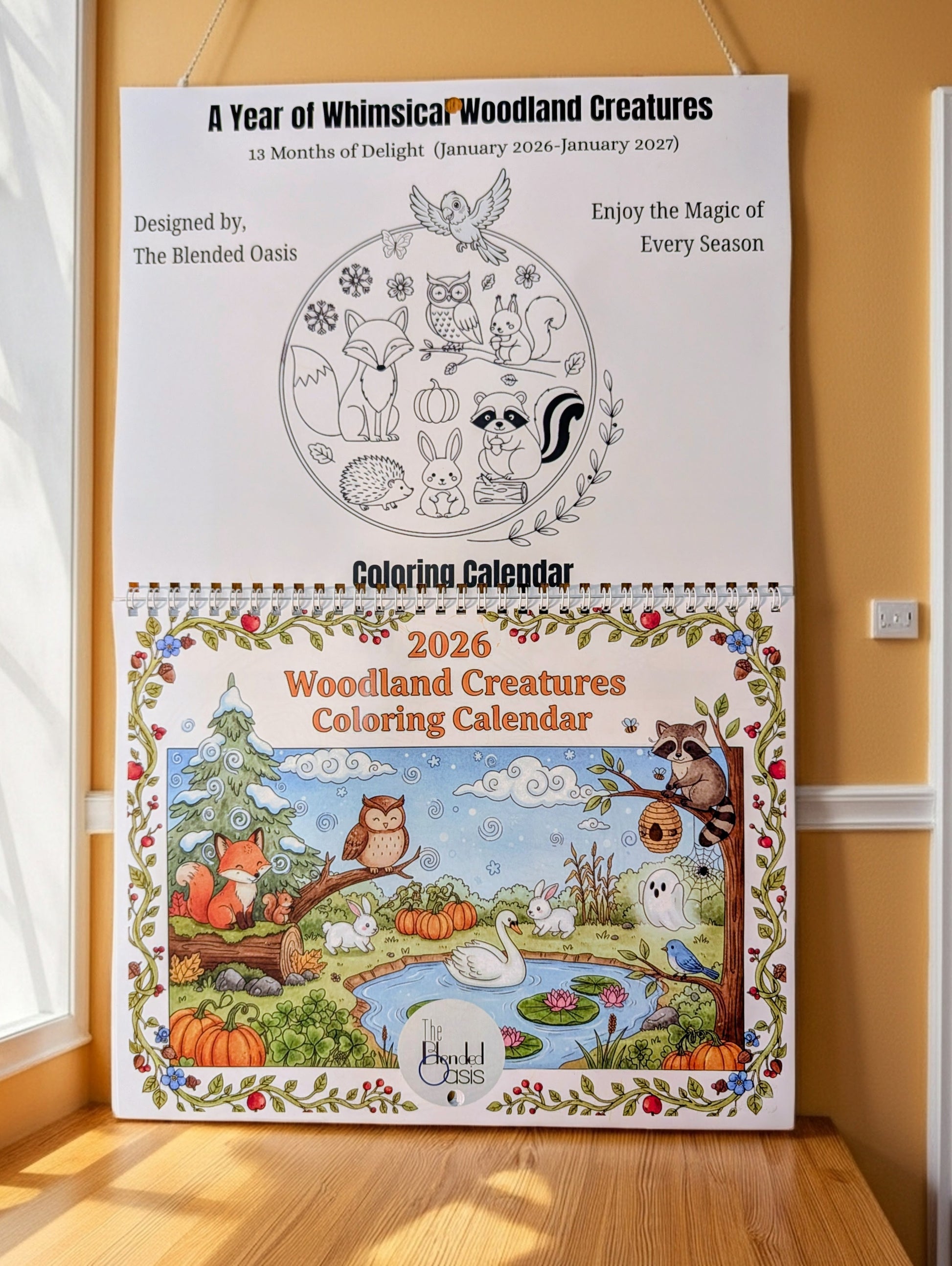 2026 Woodland Creatures Coloring Calendar on a wooden surface with a yellow wall background