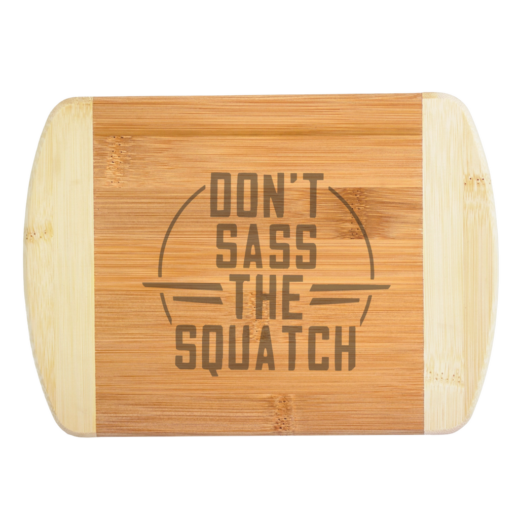 A premium engraved bamboo cutting board featuring a funny retro circular emblem layout that reads Don't Sass the Squatch, handcrafted by The Blended Oasis in Washington State