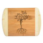 A beautiful laser-engraved bamboo cutting board featuring a symbolic design of a woman silhouette growing into a leafy tree of life with deep roots, handcrafted by The Blended Oasis in Washington State.