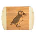 A premium engraved bamboo cutting board featuring a sleek, minimalist modern illustration of a puffin bird silhouette, handcrafted by The Blended Oasis in Washington State.