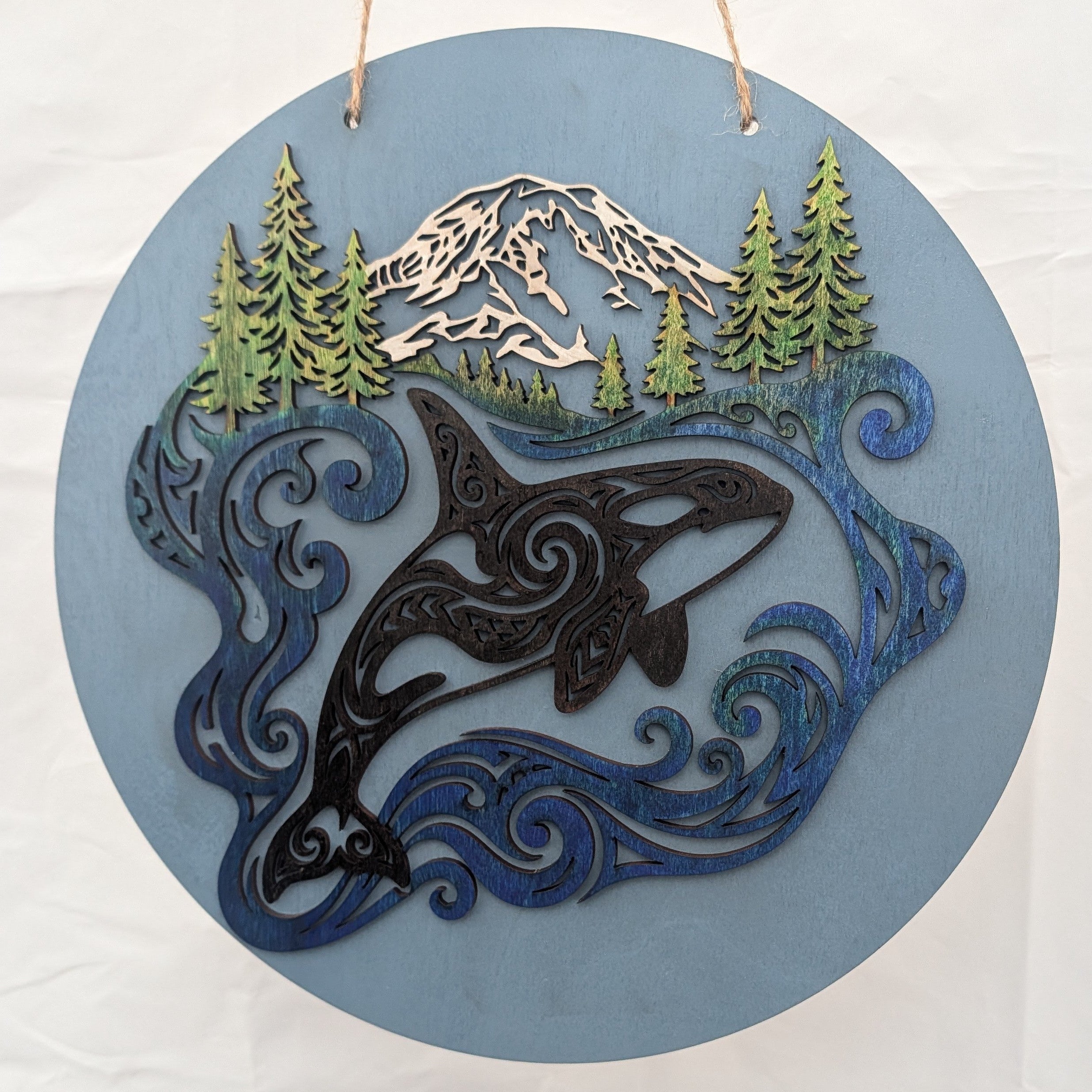 Handcrafted 3D multilayer wood wall art featuring a circular orca and mountain design by The Blended Oasis in Suquamish, Washington.