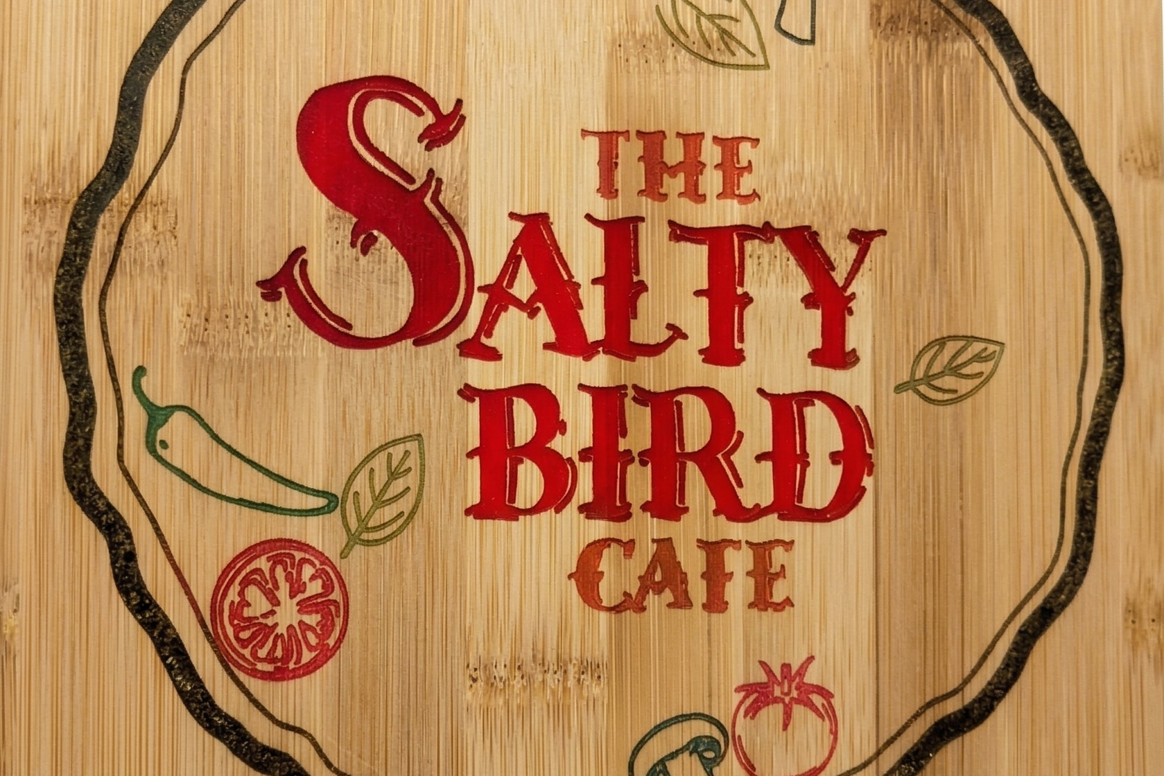 Wooden business sign with 'The Salty Bird Cafe' branding and pizza illustrations on a white background