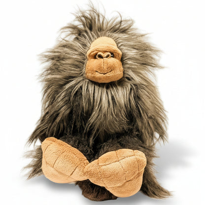 Plush toy resembling a creature with gray fur and brown face on a beige background