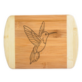 A premium engraved bamboo cutting board featuring a detailed design of a soaring hummingbird with outstretched wings, handcrafted by The Blended Oasis in Washington State.