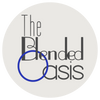 Official logo for The Blended Oasis, featuring the brand name in elegant grey typography inside a clean off-white circle with a vibrant blue accent ring, set on a transparent background.