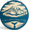 Handcrafted circular blue-stained wood wall art featuring a laser-marked design of Mount Rainier and a whale tail reflection by The Blended Oasis in Suquamish, Washington.